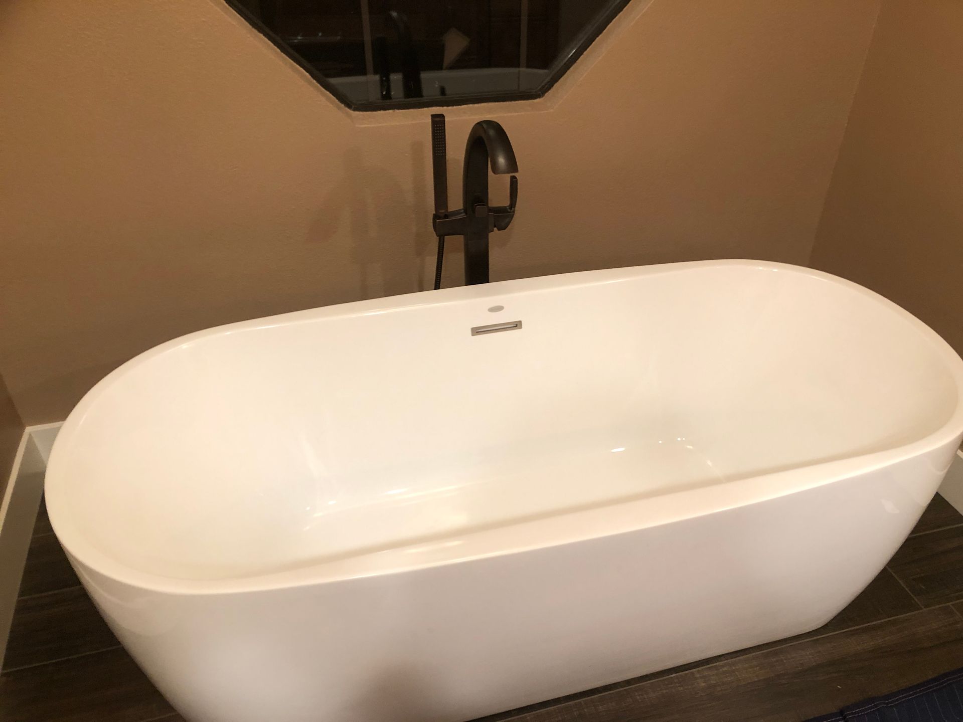 White oval freestanding bathtub in a modern bathroom