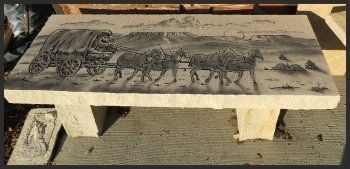 Stone bench with a carved relief of elephants on the seat, outdoors in sunlight