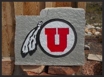 Rock with a red University of Utah “U” logo and feather emblem outdoors