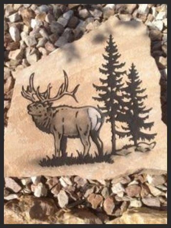 Sepia carving of a elk standing beside pine trees, surrounded by gravel