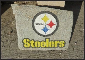 Pittsburgh Steelers logo and yellow “Steelers” text painted on a concrete block