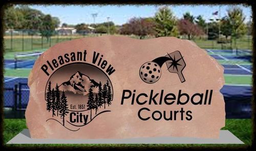 Pleasant View City Pickleball Courts sign on a court with blue and green playing surfaces