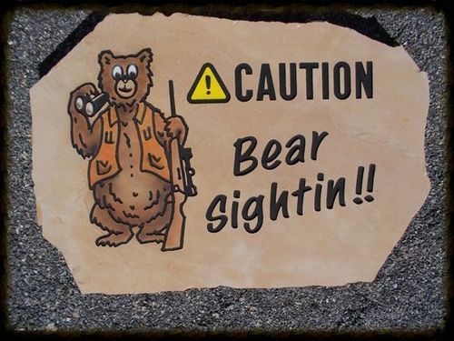 Caution sign with a cartoon bear and the words “Bear sightin!!” on a rock-shaped plaque