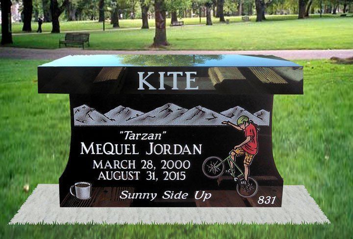 Memorial bench with “Kite” plaque in a grassy park, honoring Tarzan Mequel Jordan, 2005–2015