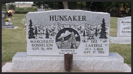Hunsaker family gravestone with engraved trees and a central portrait, in a cemetery