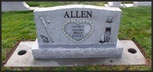 Granite headstone with “ALLEN” engraved, on a lawn with small decorative sculptures.