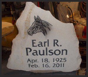 White memorial gravestone engraved with a horse and the name Earl R. Paulson, Apr. 18, 1925–Feb. 16, 2011.