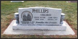 Philips family gravestone in a cemetery, with a white headstone and bronze plaque.