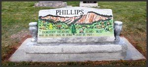 Phillips family gravestone with engraved mountain scene and flowers in a cemetery