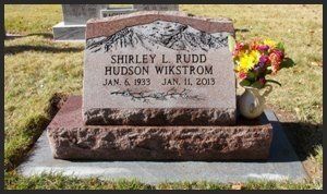 Gravestone for Shirley L. Rudd Hudson Wakistram with flowers on the right in a cemetery.
