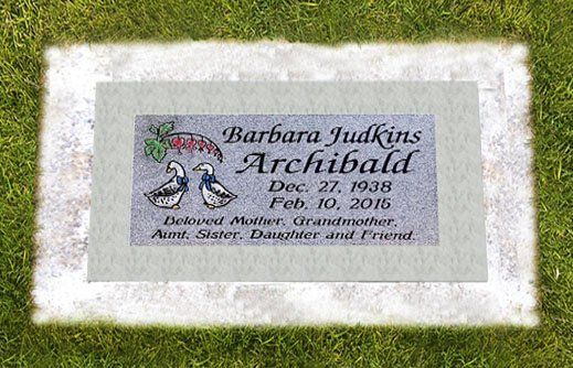 Barbara Jukins Archibald memorial plaque on grass, with flowers and dates engraved