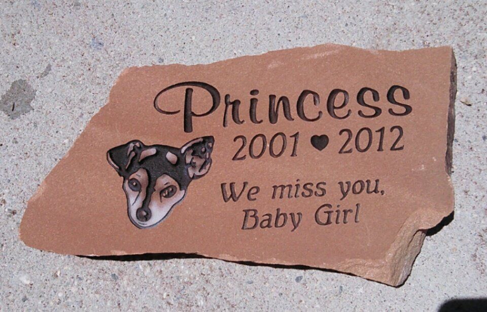 Stone memorial plaque for Princess the dog, with paw print and “2001–2012” inscription