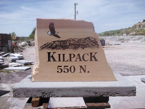 Stone Kilpack 550 N. sign on a concrete base in a quarry yard