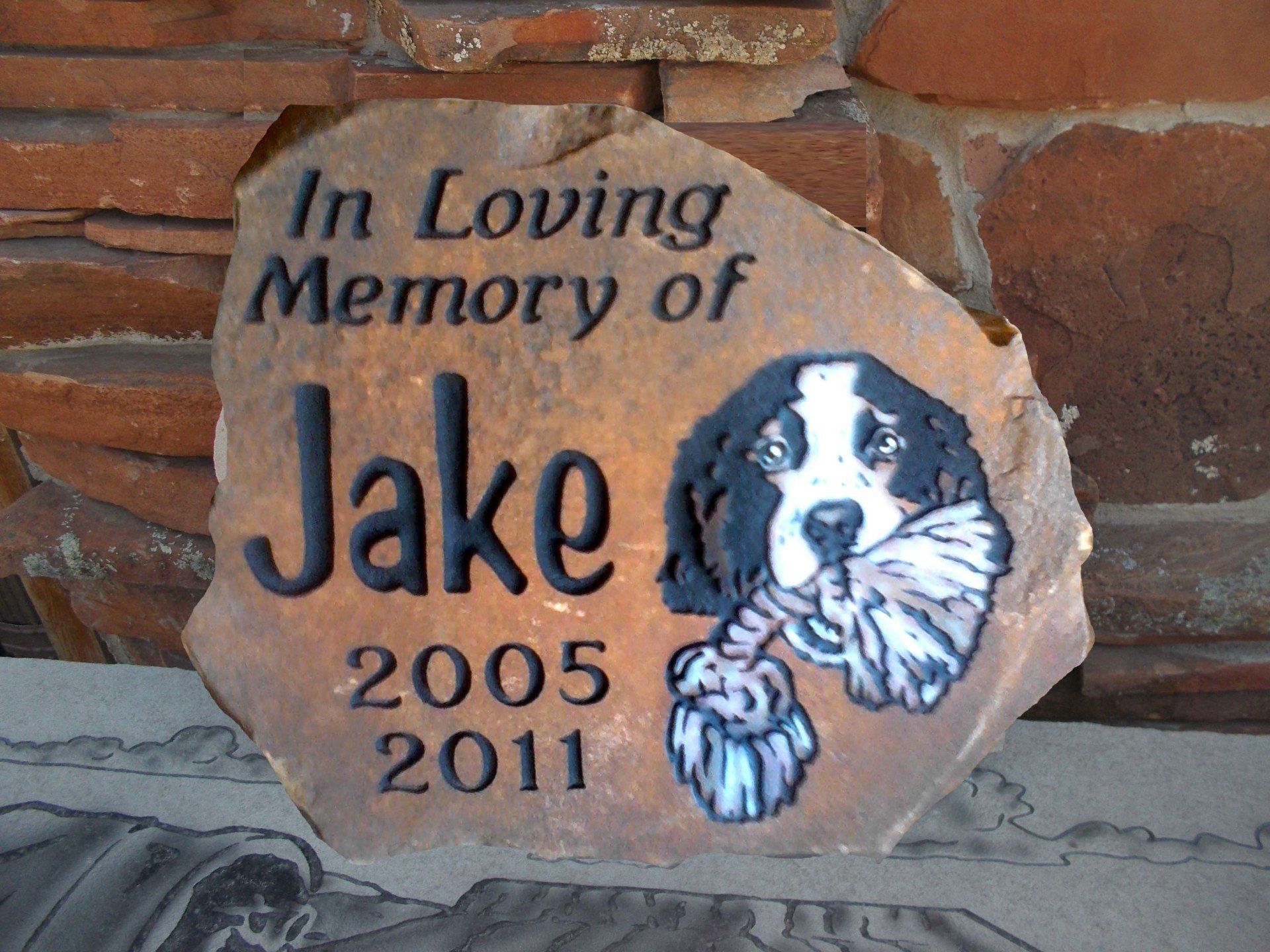 Memorial stone for Jake, with dog portrait and dates 2005–2011.
