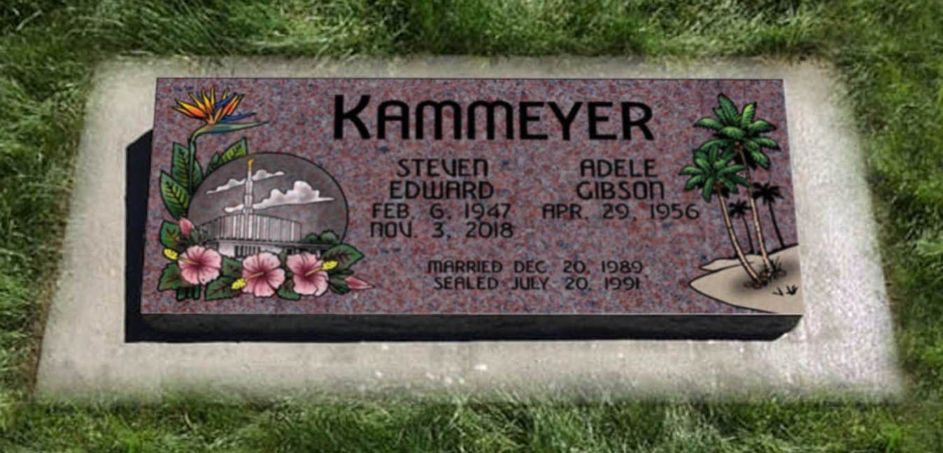 Gravestone with purple plaque, flowers, and engraved names in a grassy cemetery plot