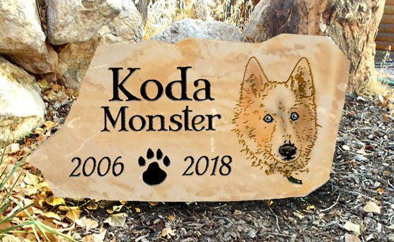 Memorial stone for Koda Monster, with dates 2006–2018 and a dog paw print and portrait.