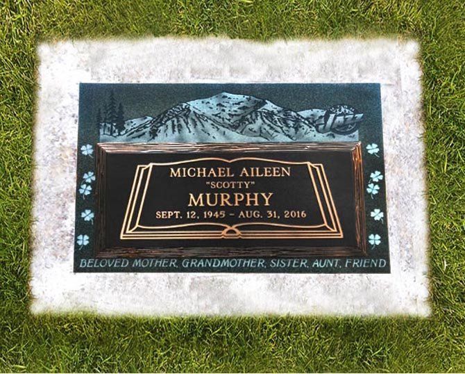 Memorial plaque on grass with white flowers and the name Michael Allen Murphy engraved in gold