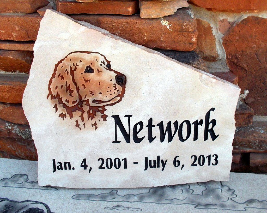 Memorial stone with a dog portrait, name “Network,” and dates Jan. 4, 2001 – July 6, 2013