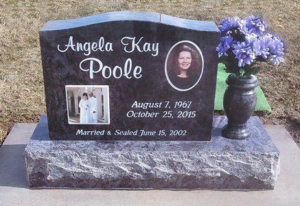 Black granite memorial headstone with inset portrait, white lettering, and purple flowers in a vase.