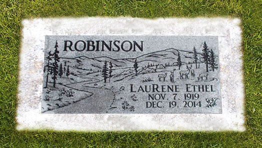 Gray gravestone in grass engraved with “ROBINSON” and “Laurie Ethel,” with etched trees and mountains