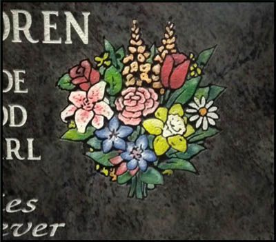 Colorful bouquet of flowers painted on a dark stone background beside partial white lettering