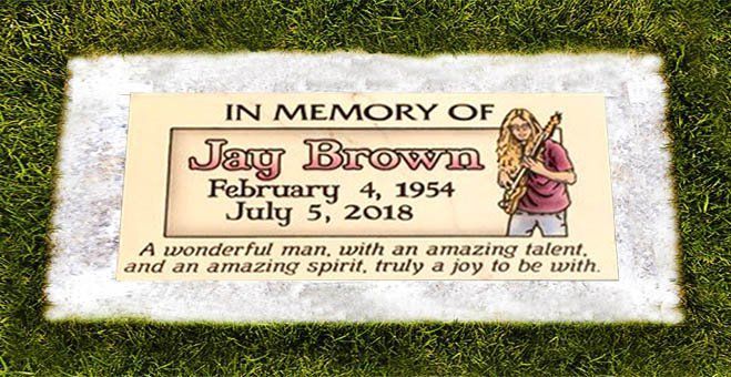 Memorial plaque on grass reading “In Memory of Jay Brown, February 4, 1954 – July 5, 2015”