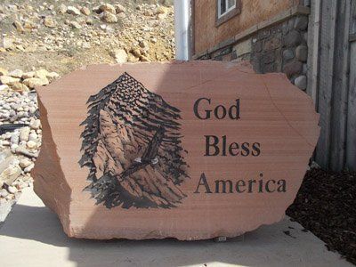 Stone plaque carved with a mountain and the words “God Bless America” outdoors