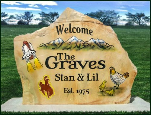Welcome stone for The Graves, Stan & Lil, with painted rocket, bird and flame in a grassy field