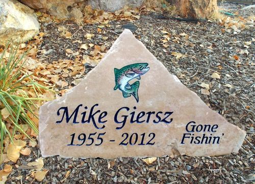 Memorial stone for Mike Gierz with a leaping fish, dates 1955–2012, and “Gone Fishin’” text