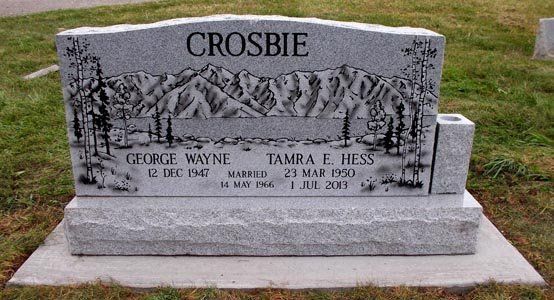 Crosbie family gravestone with mountain engraving in a grassy cemetery