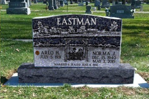 Eastman family gravestone in a cemetery, with black stone and engraved names on a grassy lawn