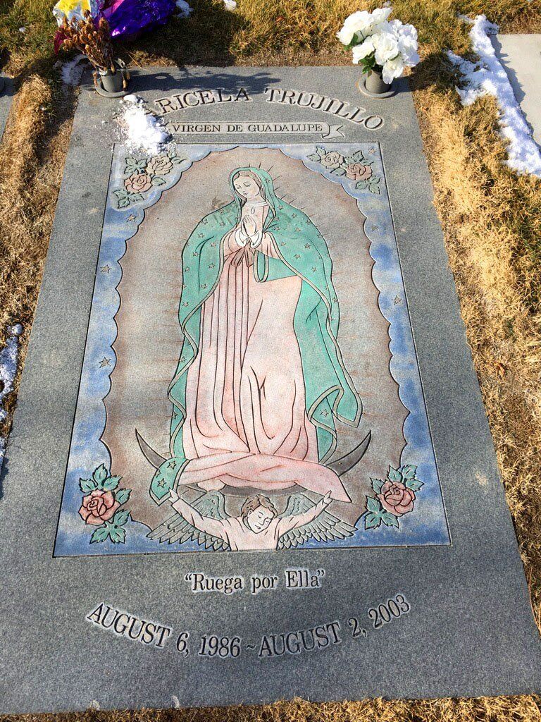 Mary and garden flowers on a decorated grave marker with engraved text
