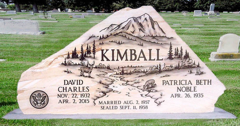 Granite mountain-shaped gravestone with “KIMBALL” and engraved names in a cemetery.