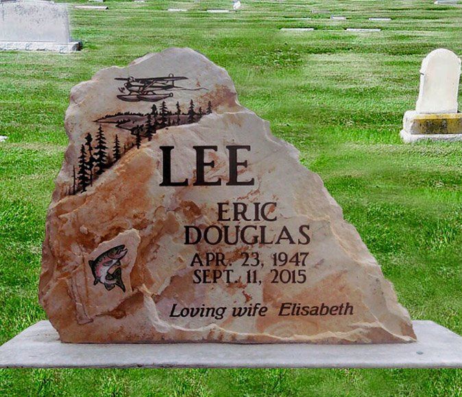Gravestone in a grassy cemetery reading “Lee Eric Douglas,” with cross, trees, and “Loving wife Elisabeth.”