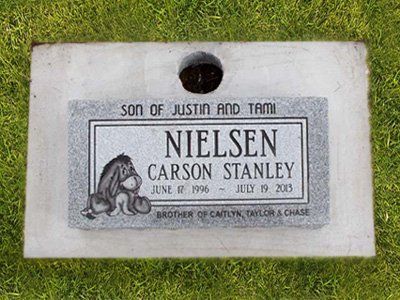 Memorial plaque in grass for Nefi Sen Carson Stanley, with a dog engraving and dates June 8, 1986–July 9, 2003