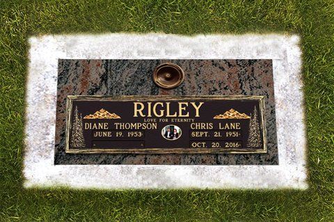Gravestone for Rigley with a black-and-gold memorial plaque in a grassy cemetery.