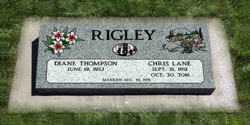 Gravestone for the Rigsley family with flowers and engraved names on a grassy lawn