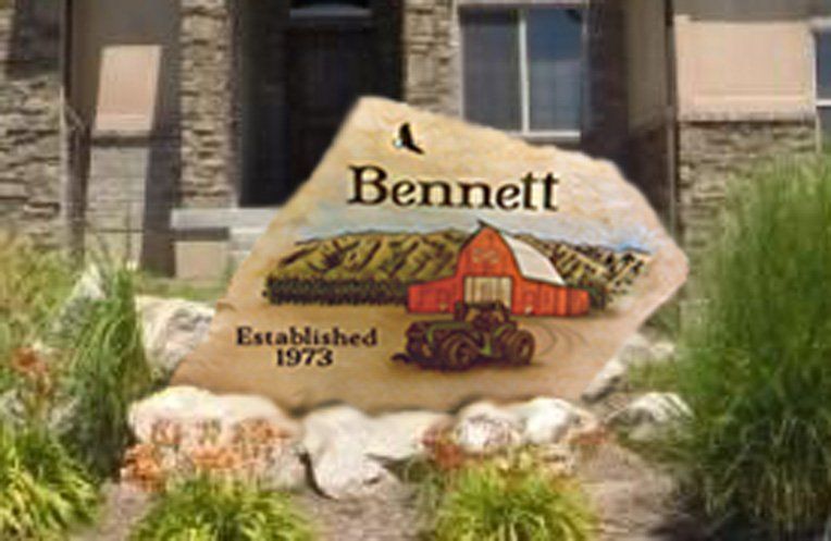 Bennett neighborhood sign with barn artwork and “Established 1973” amid landscaping