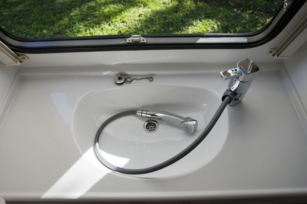 A Bathroom Sink With A Hose Attached To It — Bennett Plumbing In Broughton Village, NSW