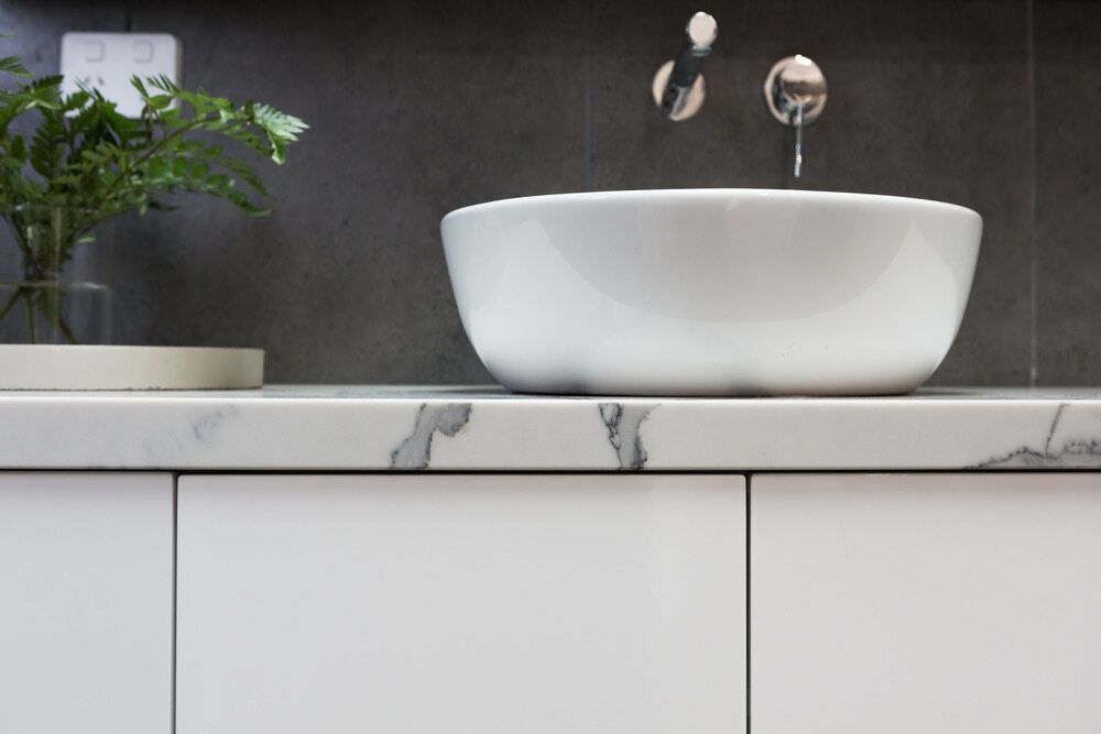 A White Sink Is Sitting On Top Of A White Counter In A Bathroom — Bennett Plumbing In Broughton Village, NSW