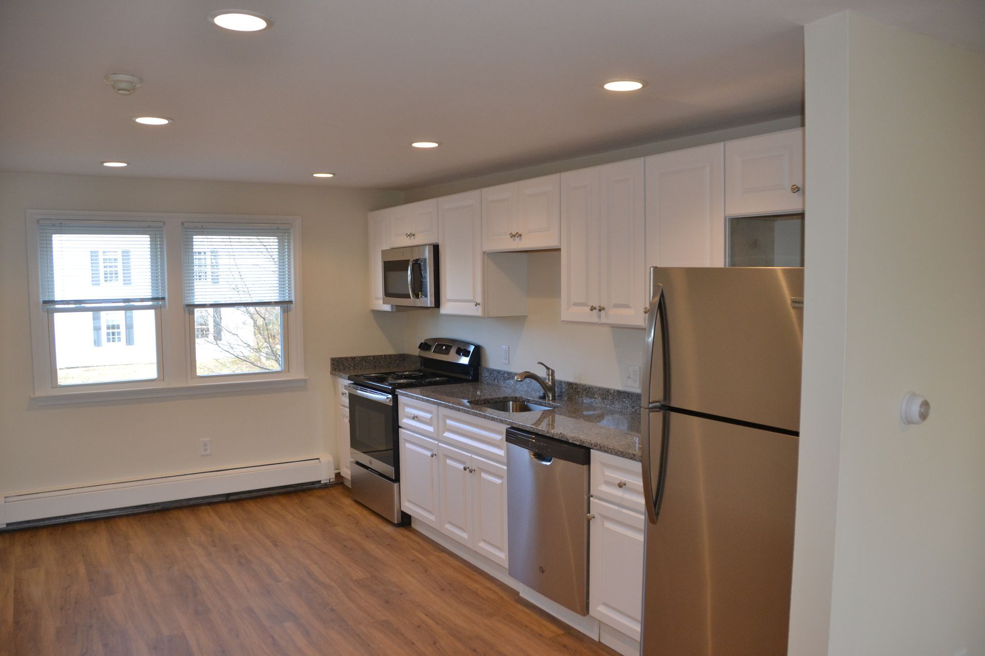 A kitchen with stainless steel appliances and white cabinets