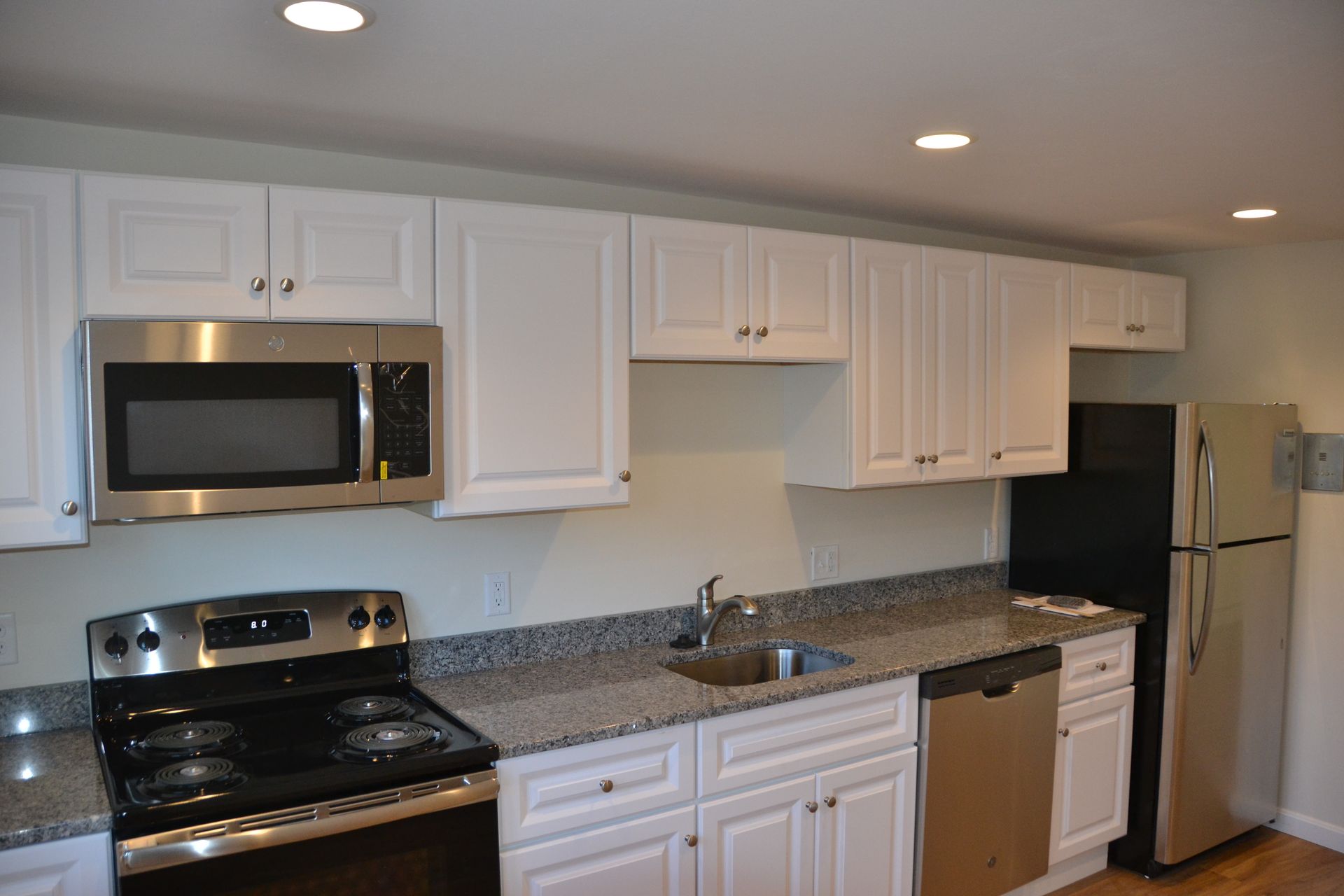 A kitchen with white cabinets and stainless steel appliances