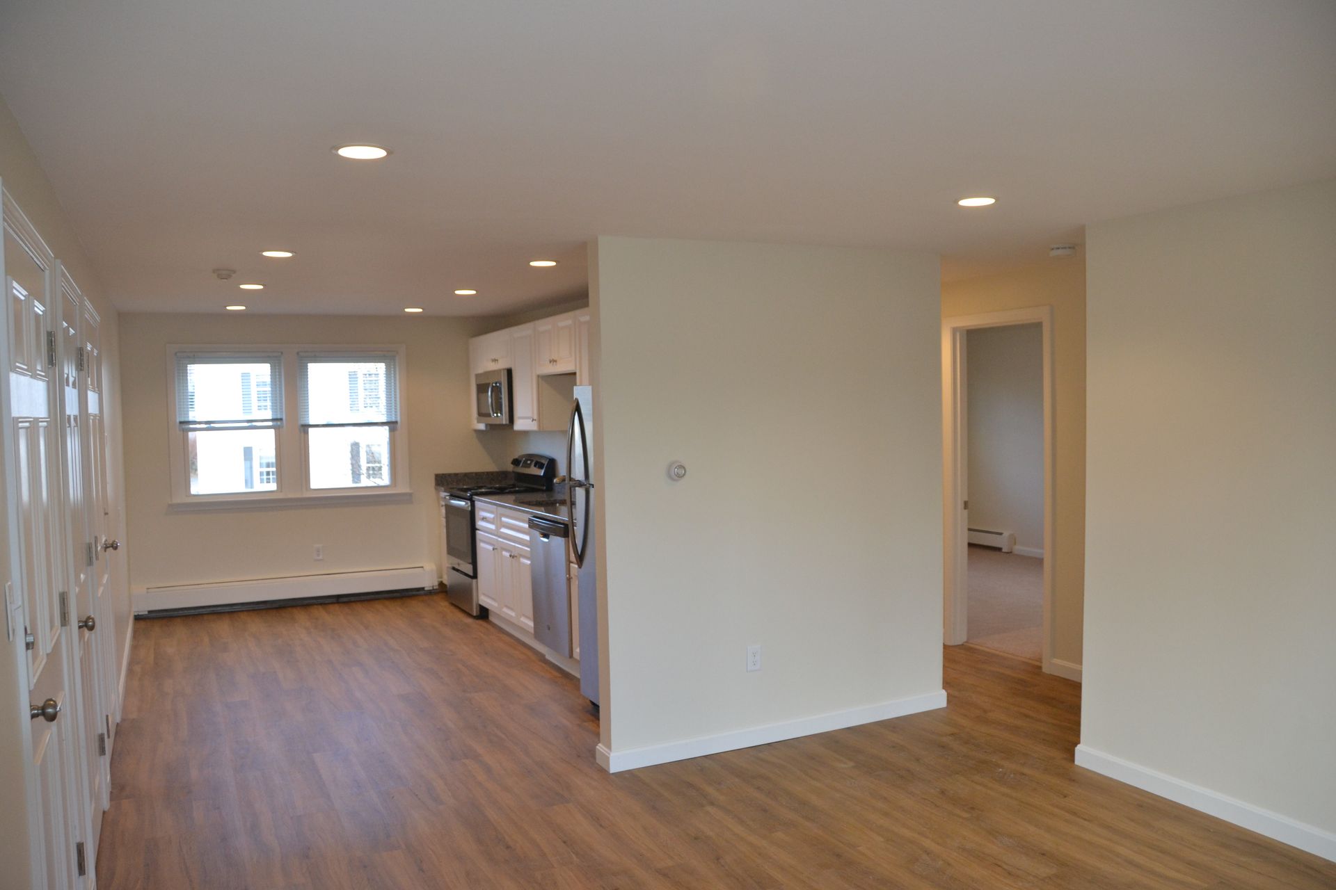 An empty apartment with a kitchen and a living room
