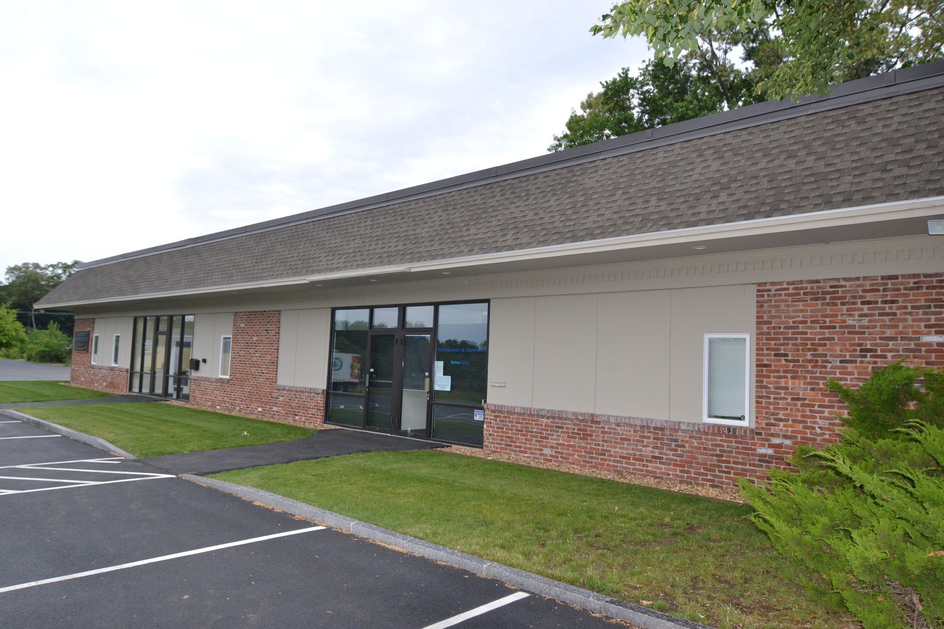 A small brick building with a parking lot in front of it