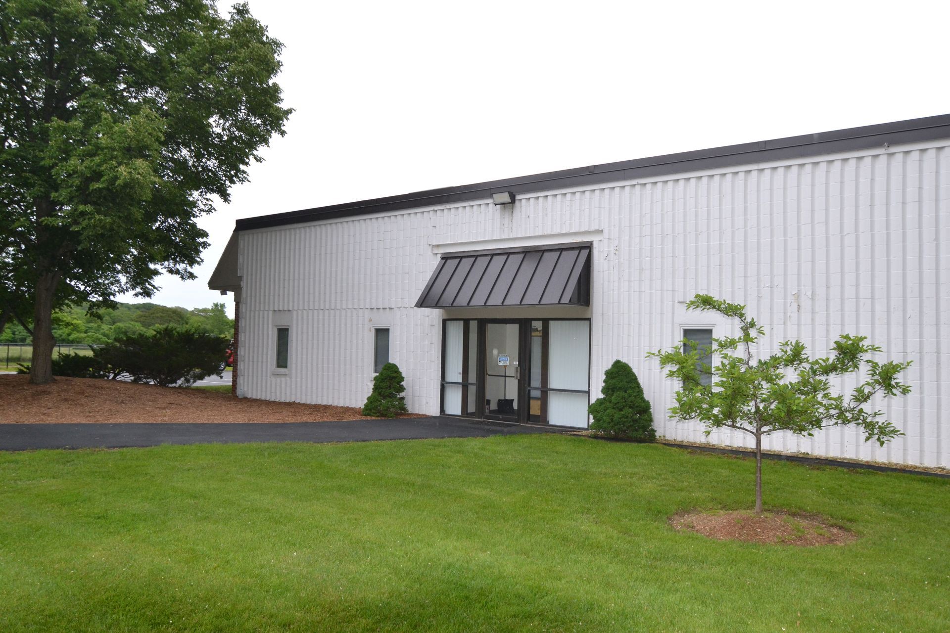 A white building with a black awning over the door