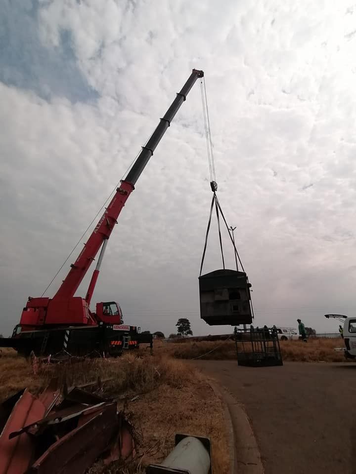 A Red Crane Is Lifting A Large Object In The Air — All Lift Cranes In St Georges Basin, NSW