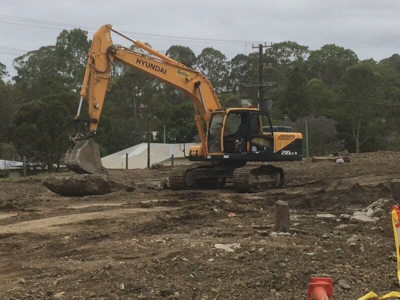 Yellow Excavator Digging in a Field — Elmac Plant Hire In Taree