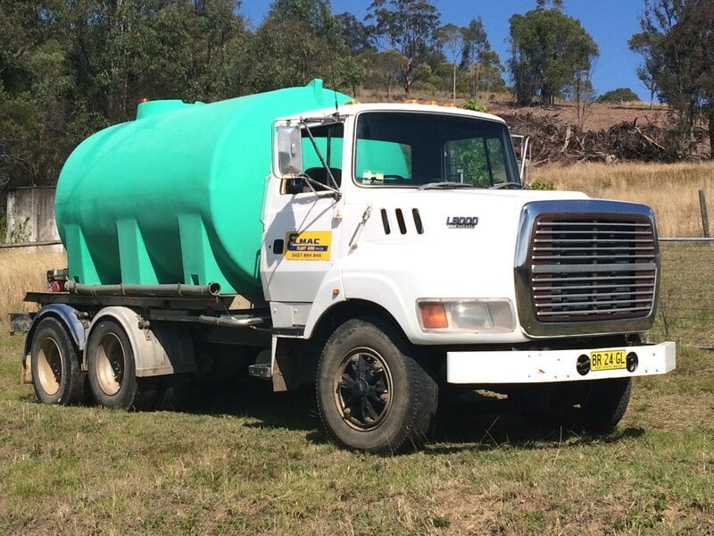 Water Truck with Aqua Tank in a Field — Elmac Plant Hire In Taree