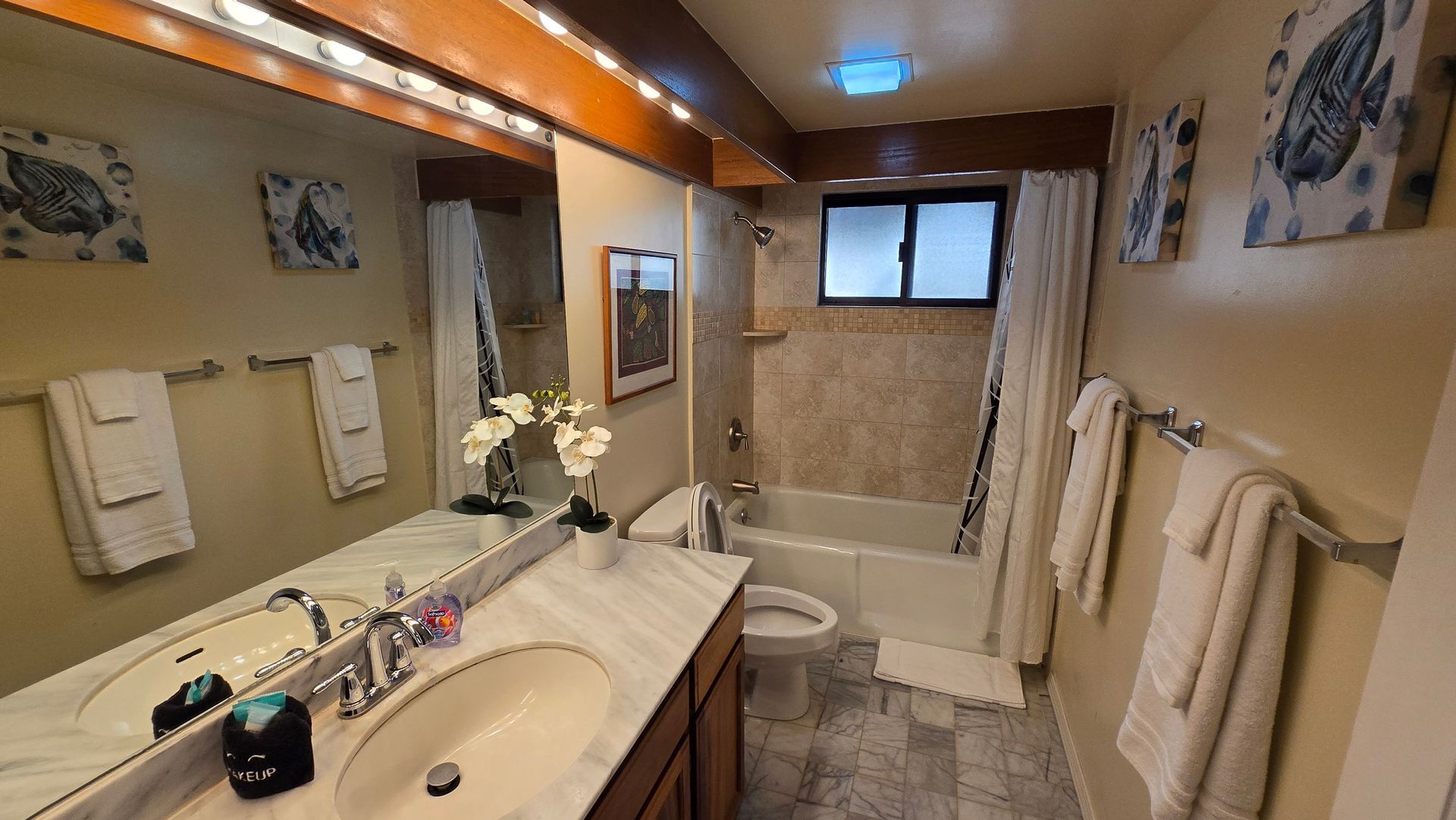 Bathroom with marble countertop, beige walls, and white towels.