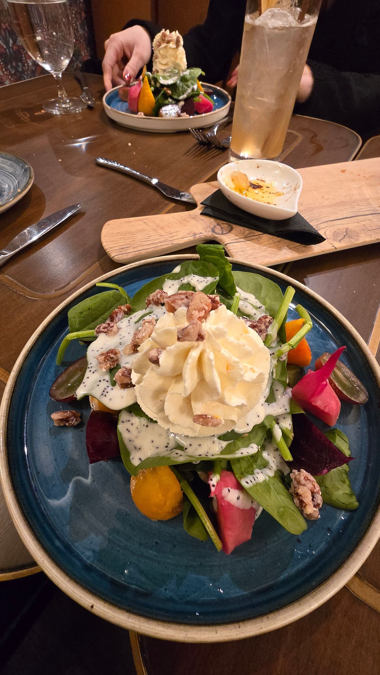 Plated dessert with cream and fruit on a blue plate in a restaurant setting